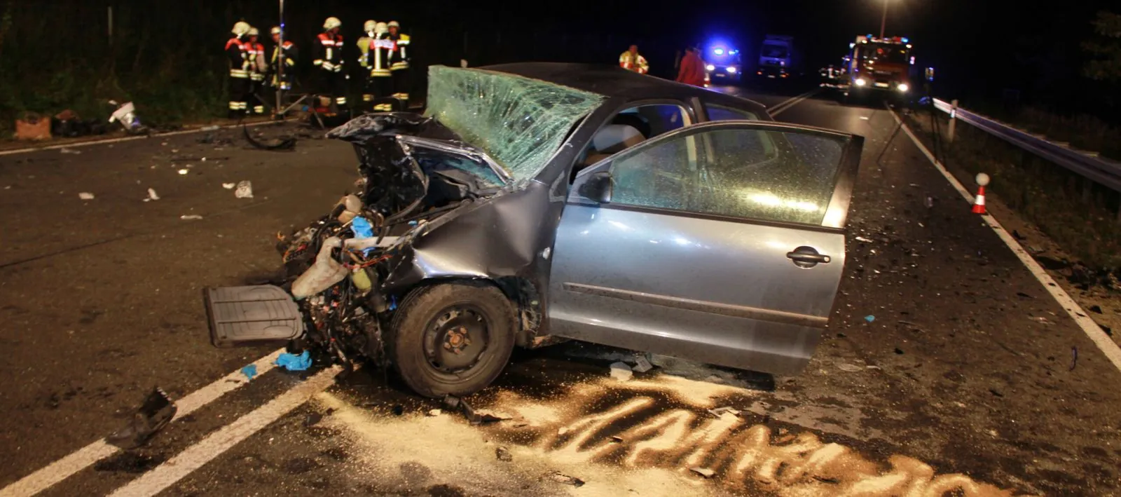 Beschädigtes Fahrzeug an einer Unfallstelle bei Nacht